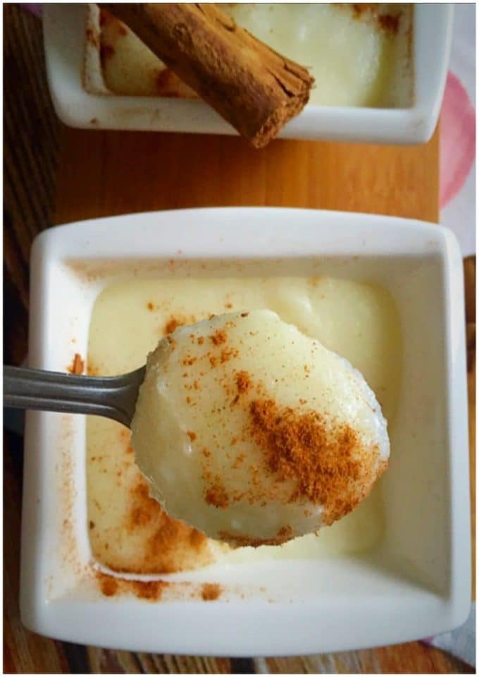 A white bowl with semolina pudding and a teaspoon scooping some pudding
