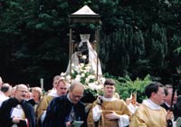 Priests in Anglican robes carry an image of Mary in a procession