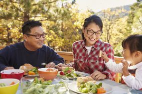 A family eating a healthy meal outdoors